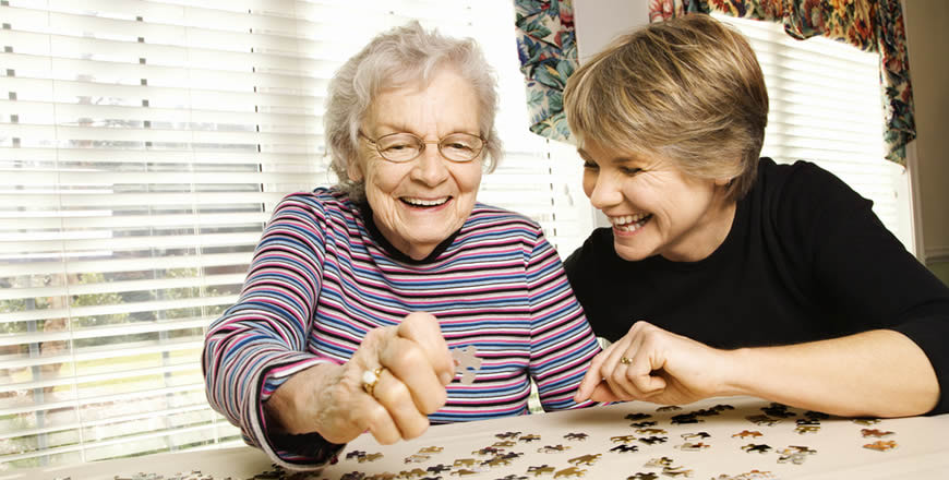 elderly woman wit jig saw puzzle and assisted living placement agent